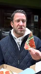 Dave Fartnoy reviewing pizza on camera 