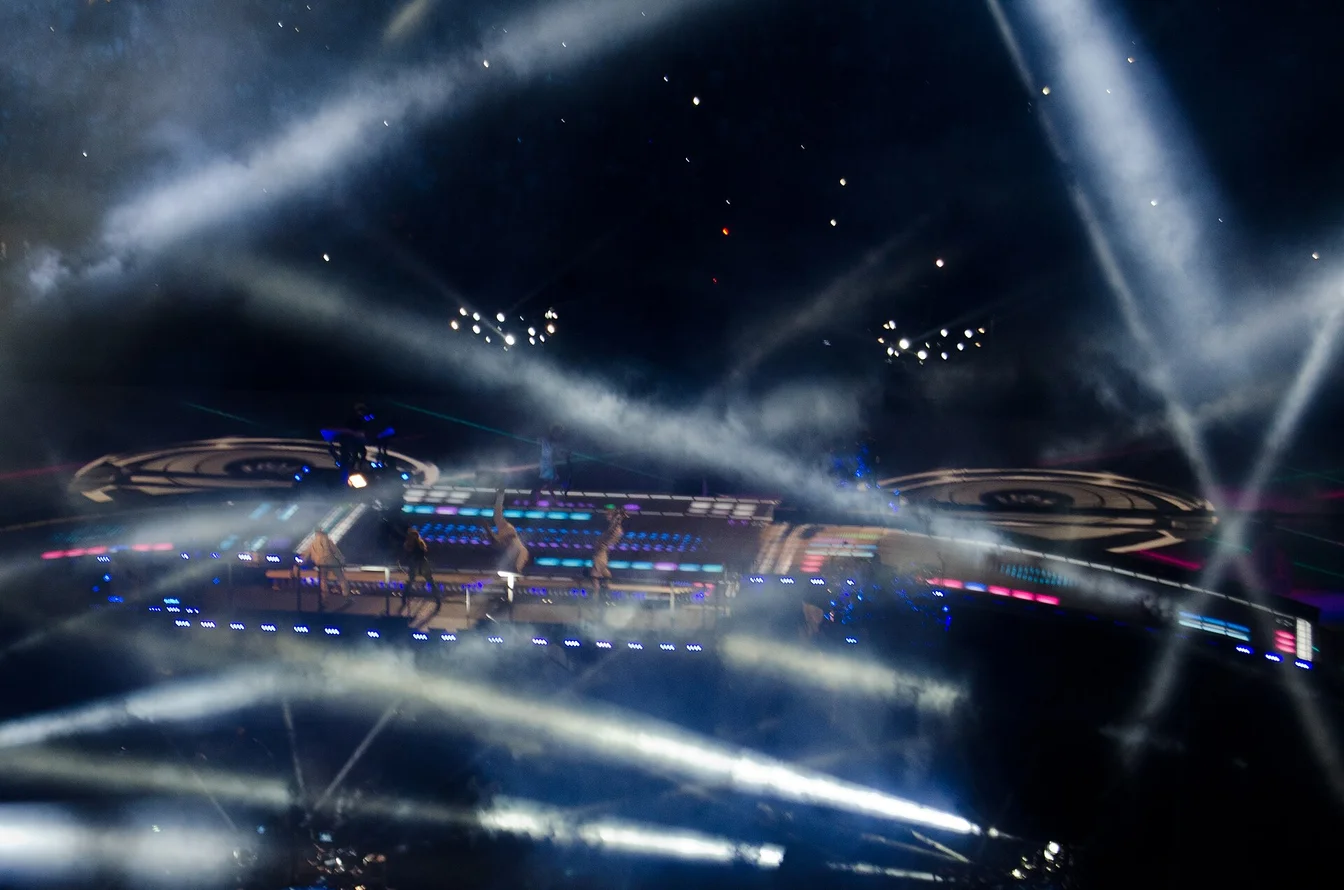 Rihanna performing at the Super Bowl Halftime Show on the floating platform, red jumpsuit