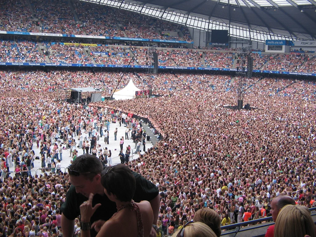 Lady Gaga waving to fans from the Chromatica Ball stage with confetti falling