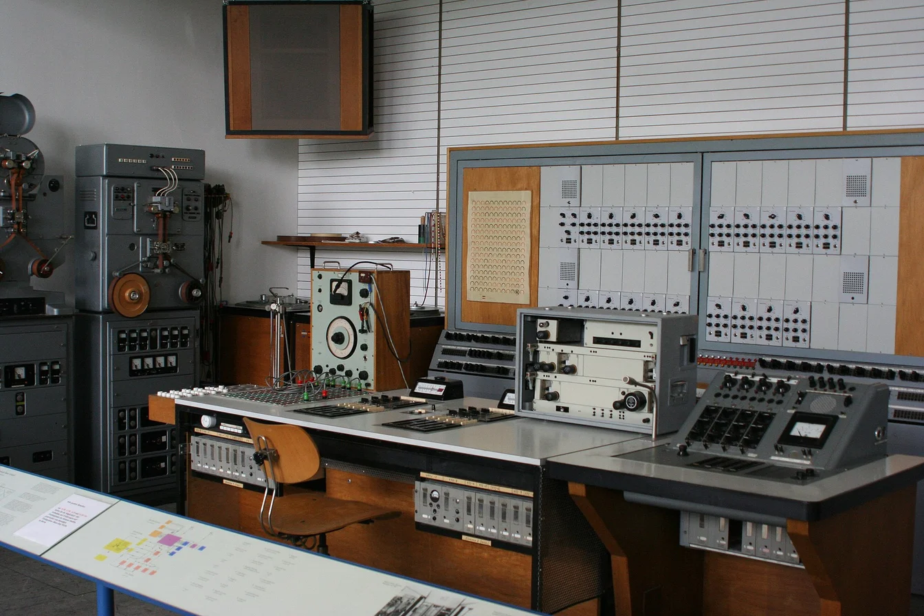 Doja Cat in the recording studio surrounded by synthesizers and production equipment, working on the Planet Her sequel